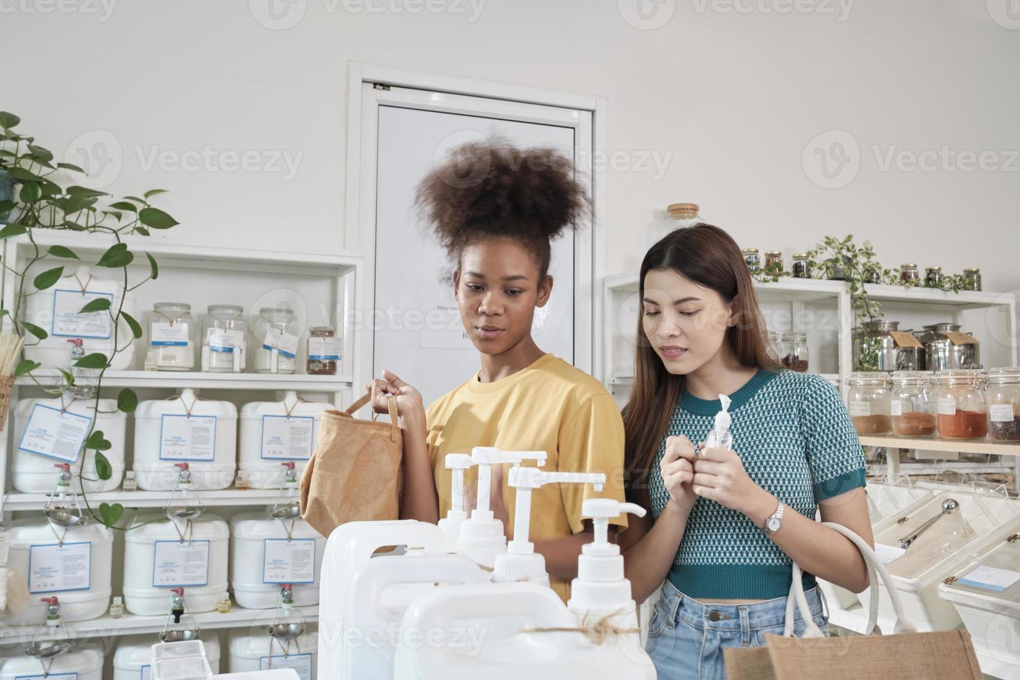 Two female customers are happy and enjoy shopping with natural organic products with recycled bottles at zero-waste and refill store, environment-friendly groceries, and sustainable lifestyles retail. photo
