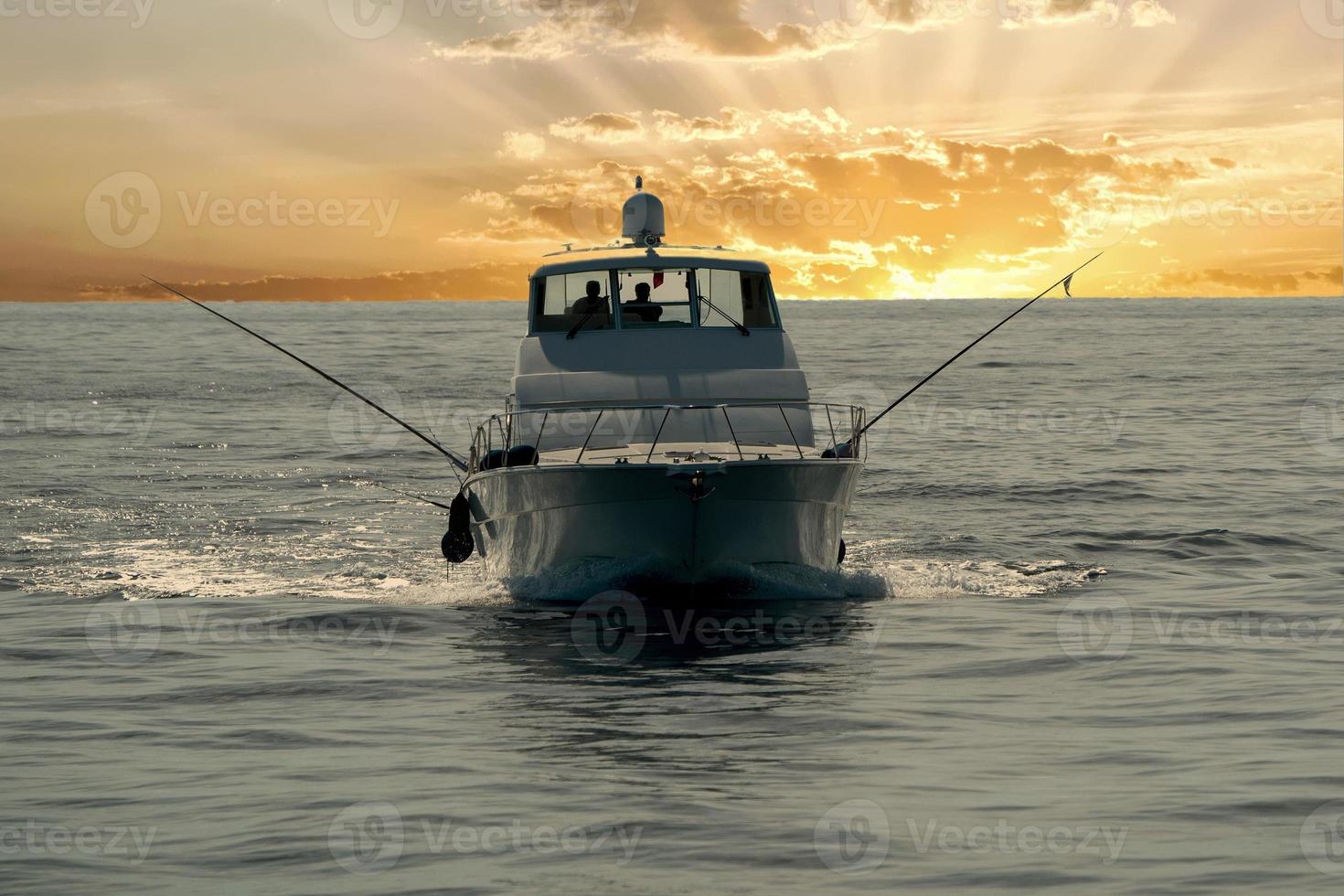 small touristic fishing boat returning in harbor at sunset photo