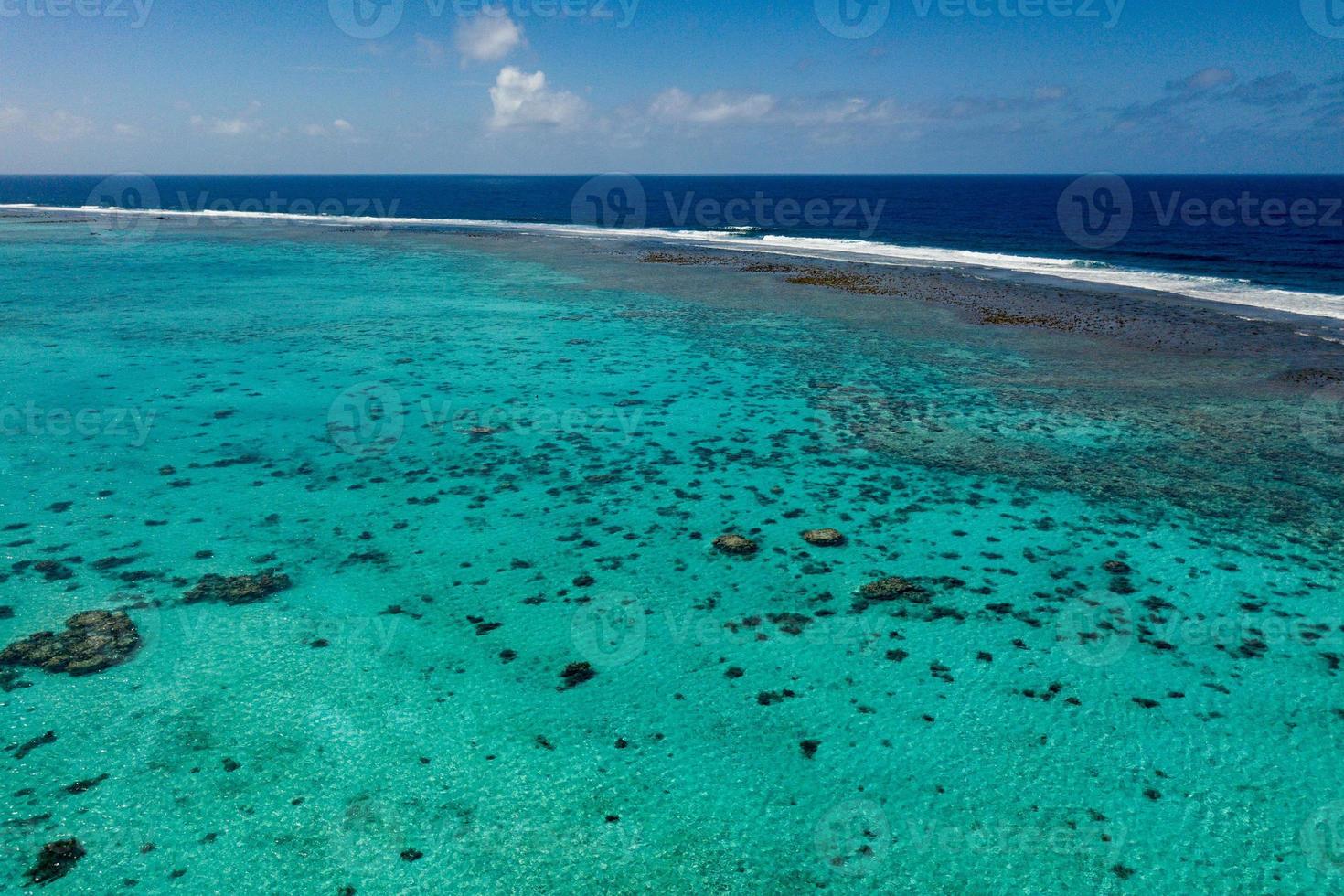 vista aérea de las olas en el arrecife de las islas cook de polinesia foto