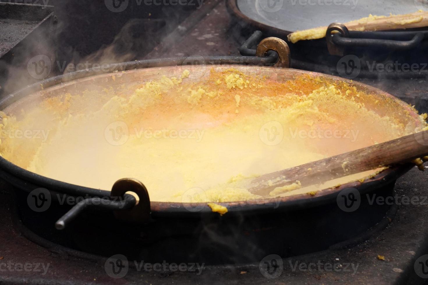 RANGO, ITALY - DECEMBER 8, 2017 - People cooking polenta traditional corn wheat meal photo