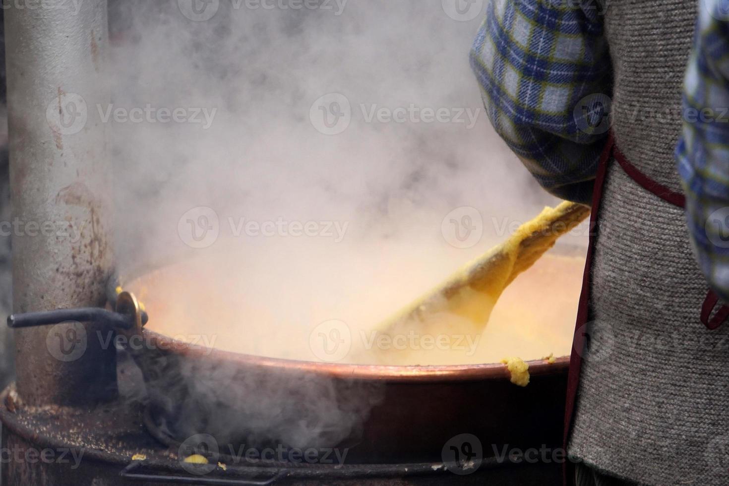 rango, italia - 8 de diciembre de 2017 - gente cocinando polenta harina tradicional de maíz y trigo foto