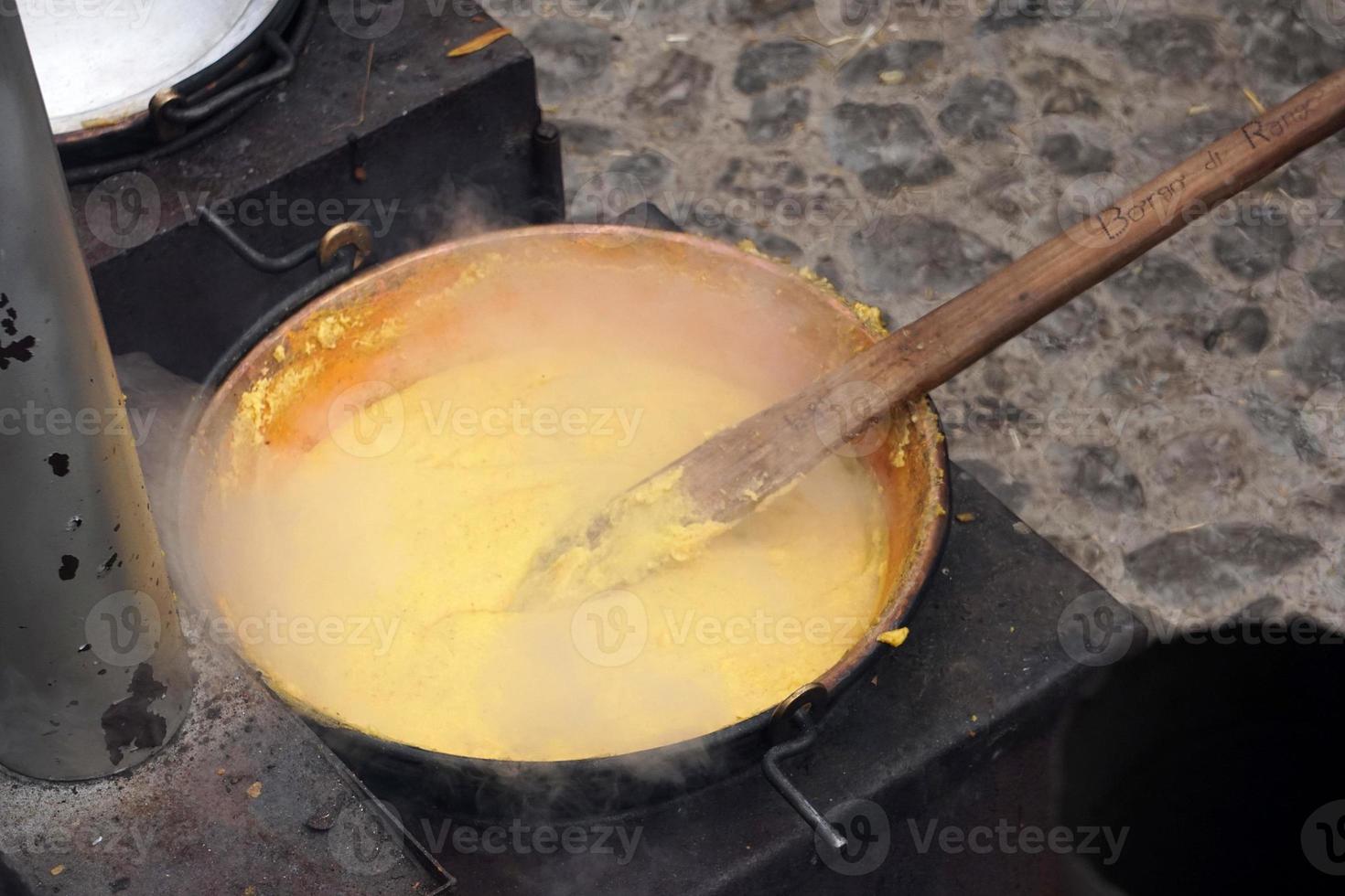 RANGO, ITALY - DECEMBER 8, 2017 - People cooking polenta traditional corn wheat meal photo