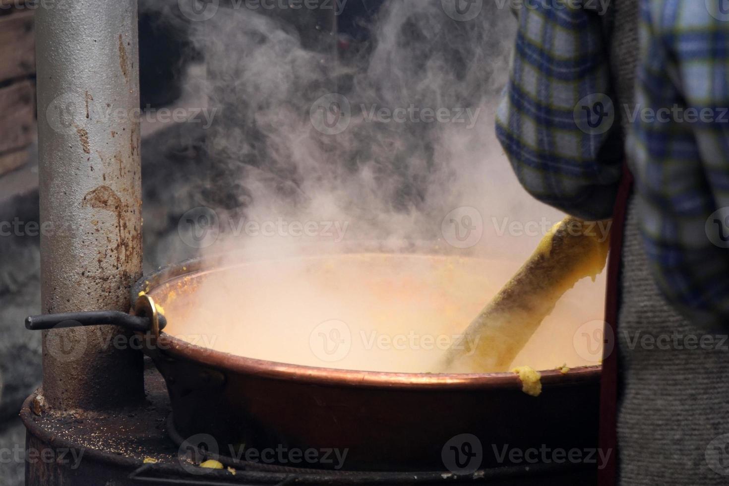 RANGO, ITALY - DECEMBER 8, 2017 - People cooking polenta traditional corn wheat meal photo