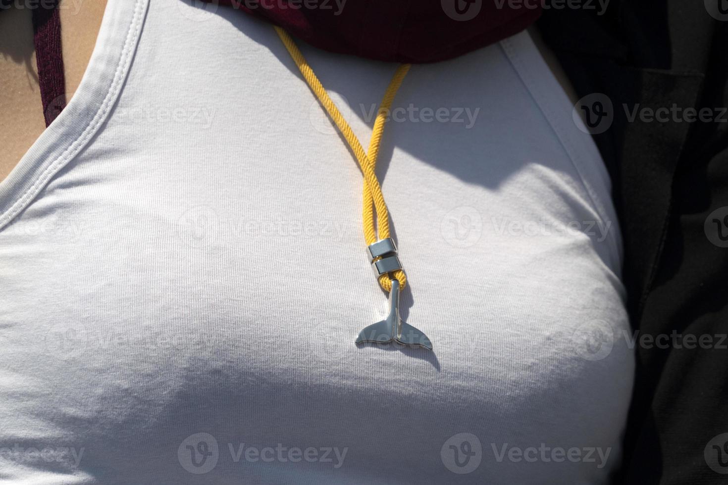 whale tail pendant on woman breast photo