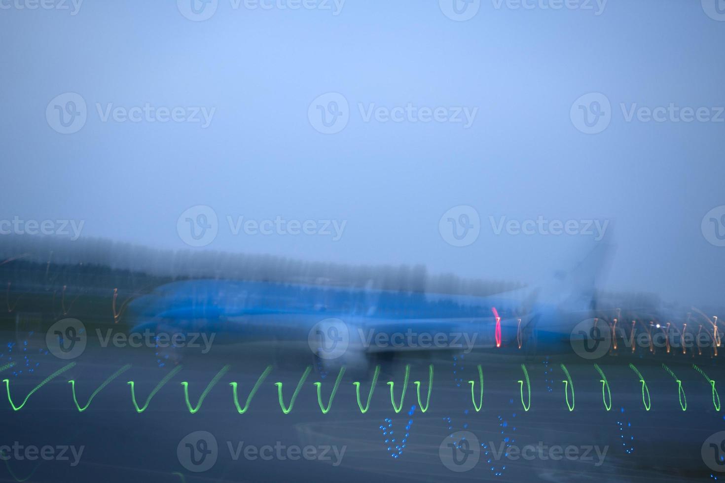 luces del aeropuerto en movimiento mientras el avión despega por la noche foto