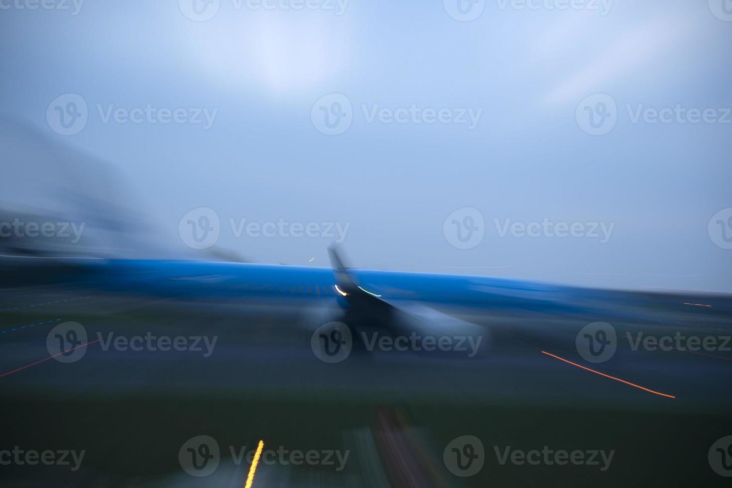 luces del aeropuerto en movimiento mientras el avión despega por la noche foto