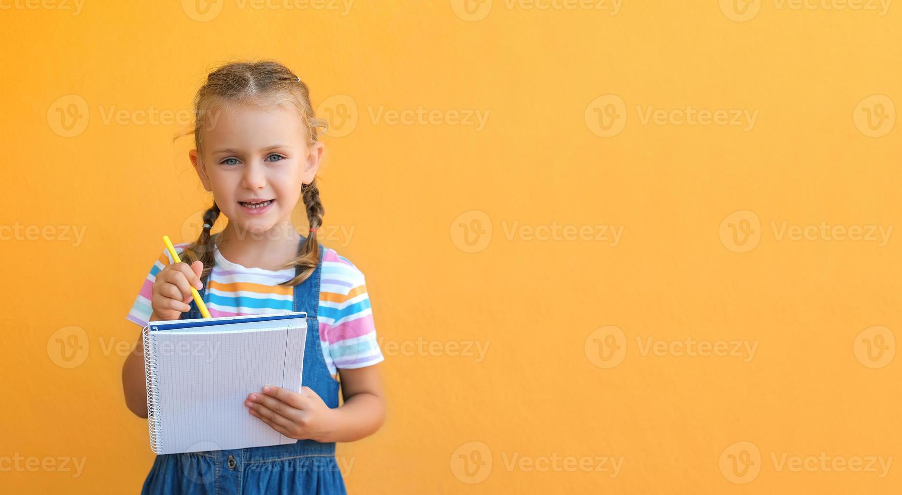 Child making notes. Kids dreams.Isolated on yellow background.Education products goods. Kid back to school. Mock up, copy space photo