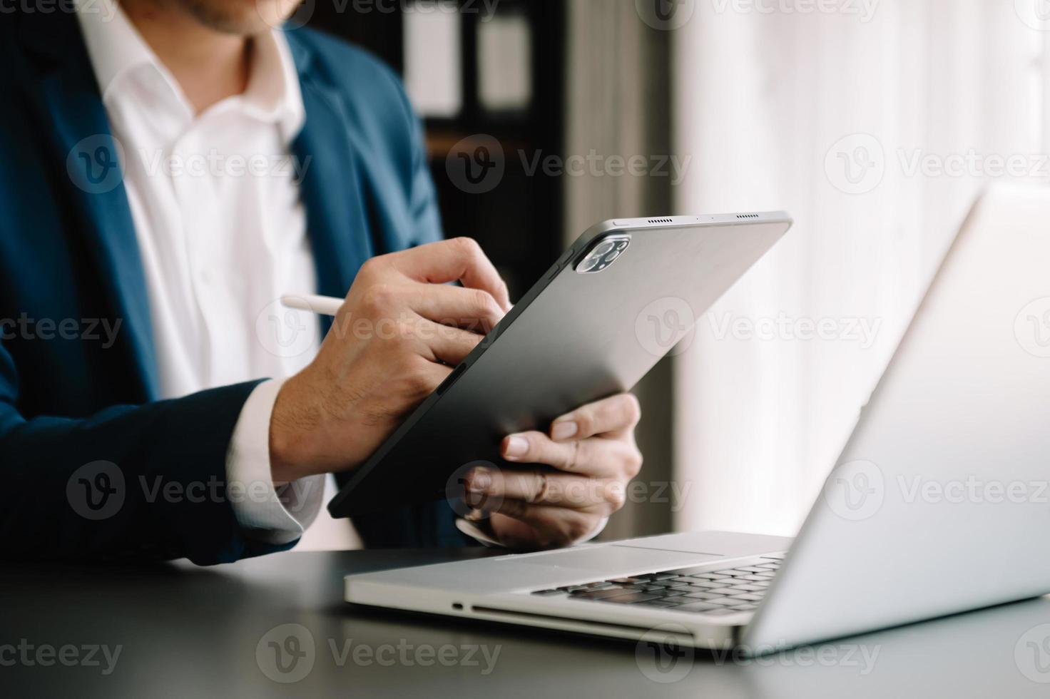 mano de hombre de negocios usando un teléfono inteligente, pagos de tabletas, compras en línea, canal omni, computadora de teclado de acoplamiento de tableta digital en la oficina foto