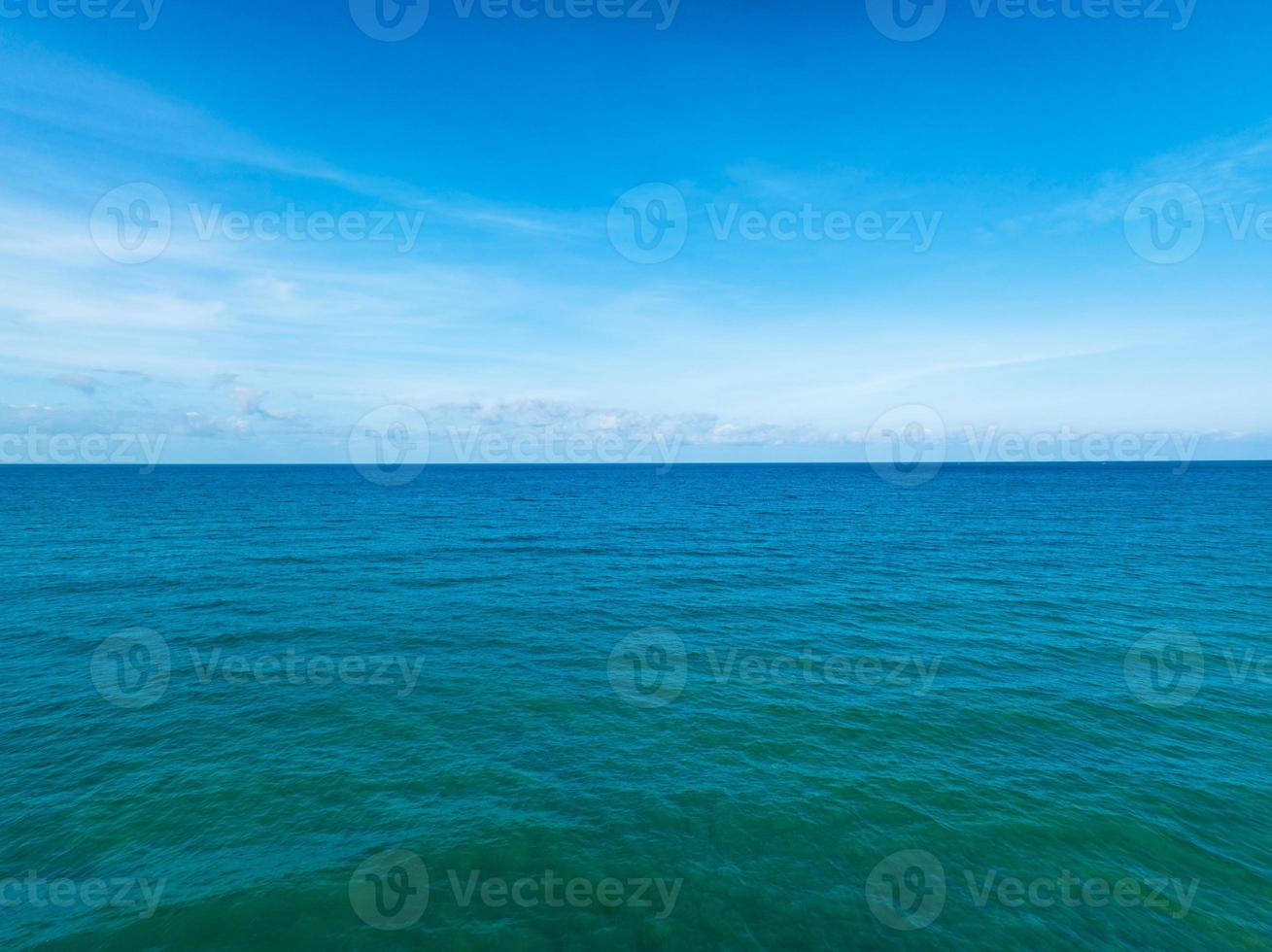 vista aérea de un fondo de textura de agua de superficie de mar azul, vista aérea vista de drones voladores ondas textura de superficie de agua en un día soleado, fondo de cielo azul de océano tropical foto