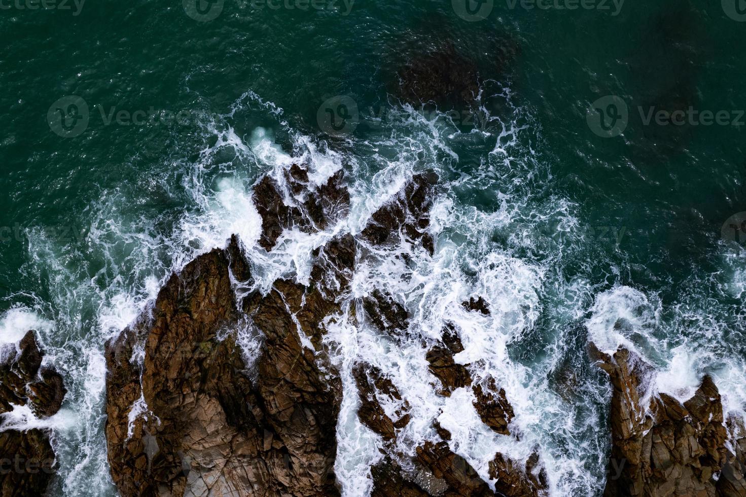 Amazing top view beautiful seashore, Aerial view crashing waves on rocks, Dark sea surface seashore rocks cliffs background photo