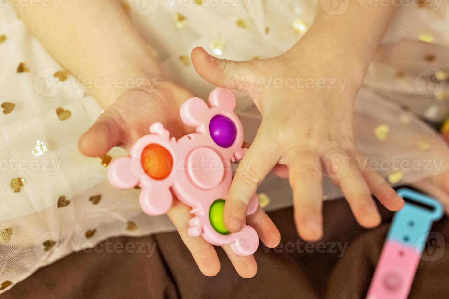 Pop it is a multi-colored anti-stress toy in children's hands. Bubble game. Antistress toys. photo