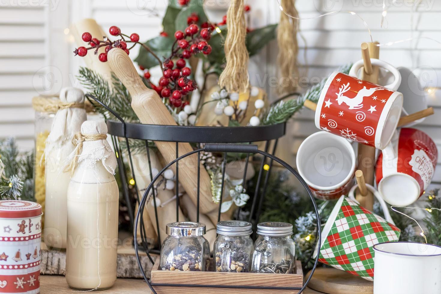 mesa en la cocina con botellas de leche, tazas y adornos navideños foto
