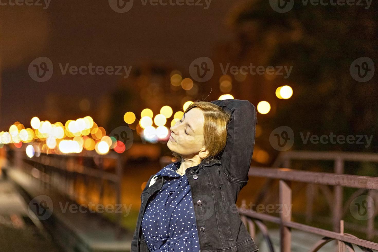 retrato de una mujer joven en una ciudad nocturna en una tarde de verano. Luces de la ciudad foto