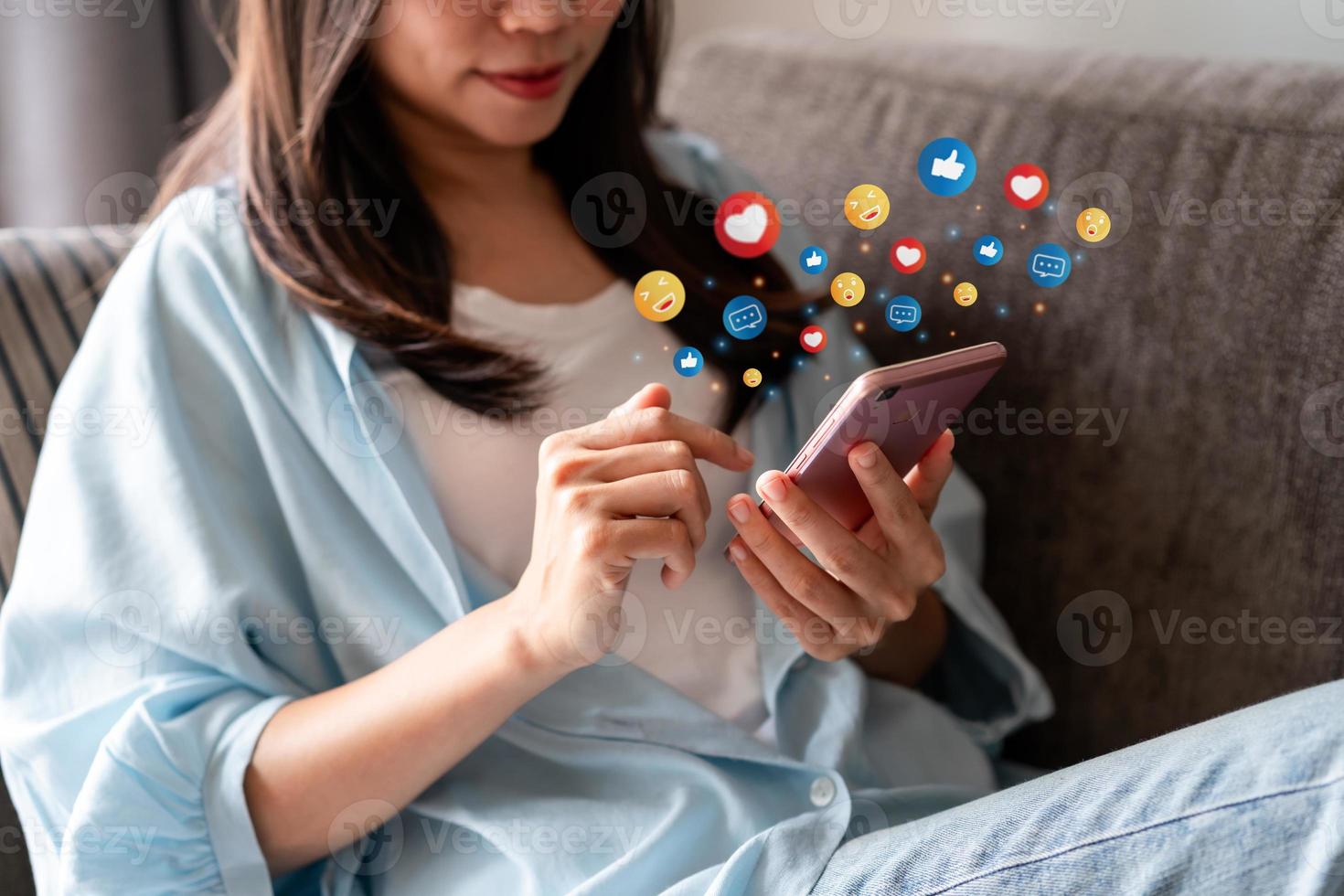 Young woman using mobile phone and relaxing at home, Modern lifestyle and social media concept. photo