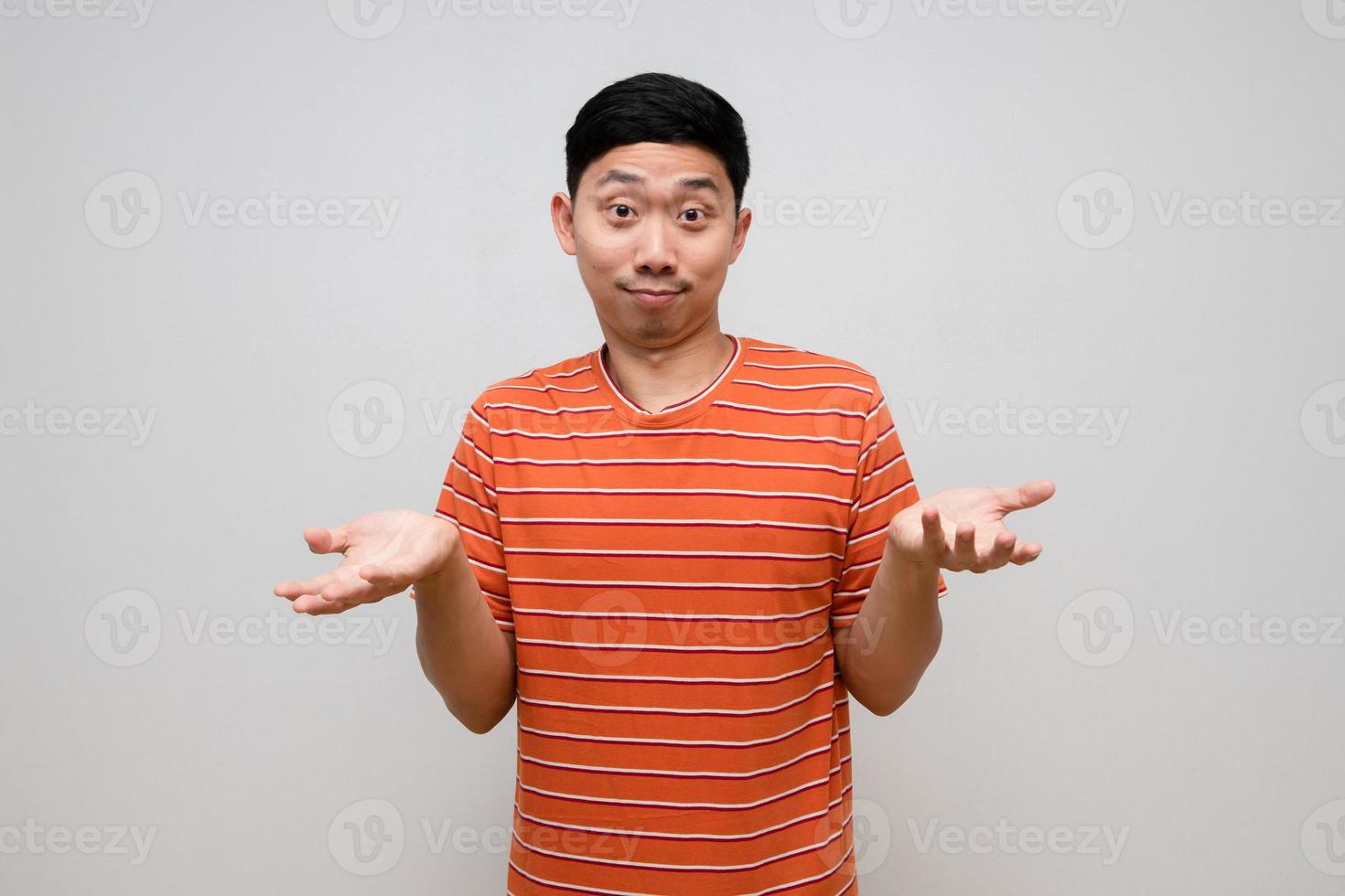 Positive asian man striped shirt handsome show hands up about I dont know isolated photo