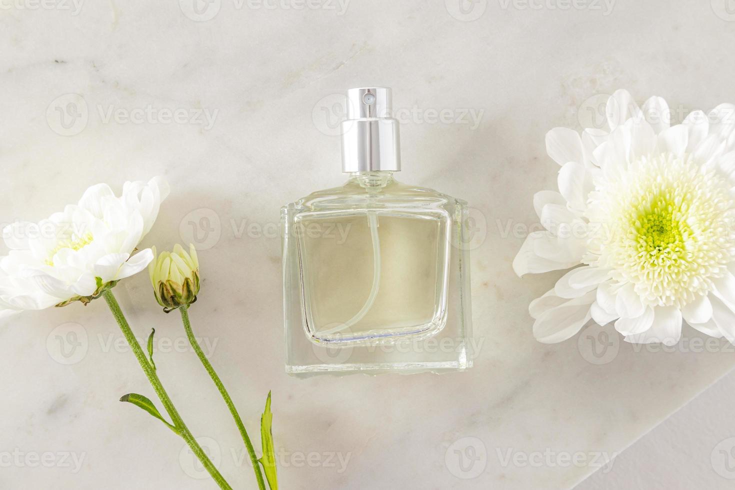 una elegante botella de perfume caro o agua de tocador sobre un fondo de  mármol con flores blancas. vista superior. una maqueta vacía de la botella.  publicidad. 18747695 Foto de stock en