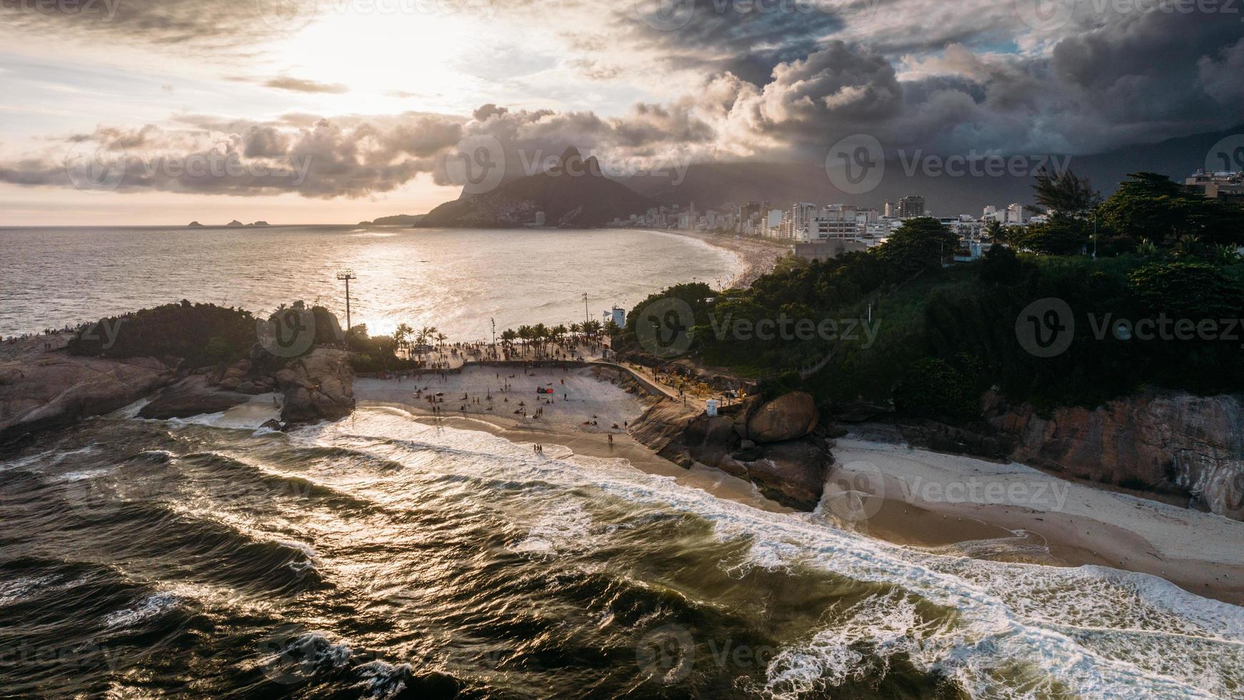 vista aérea de drones sobre las playas de praia do diabo, arpoador e ipanema en río de janeiro, brasil en un día nublado con muchos cariocas disfrutando de las playas foto