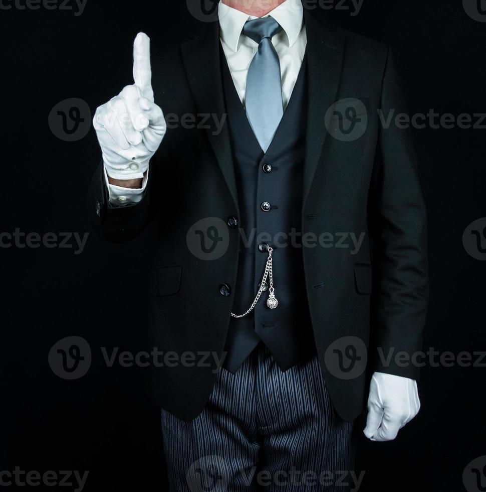 retrato de mayordomo con traje oscuro sobre fondo negro con guantes blancos limpios. concepto de industria de servicios y hospitalidad profesional. foto