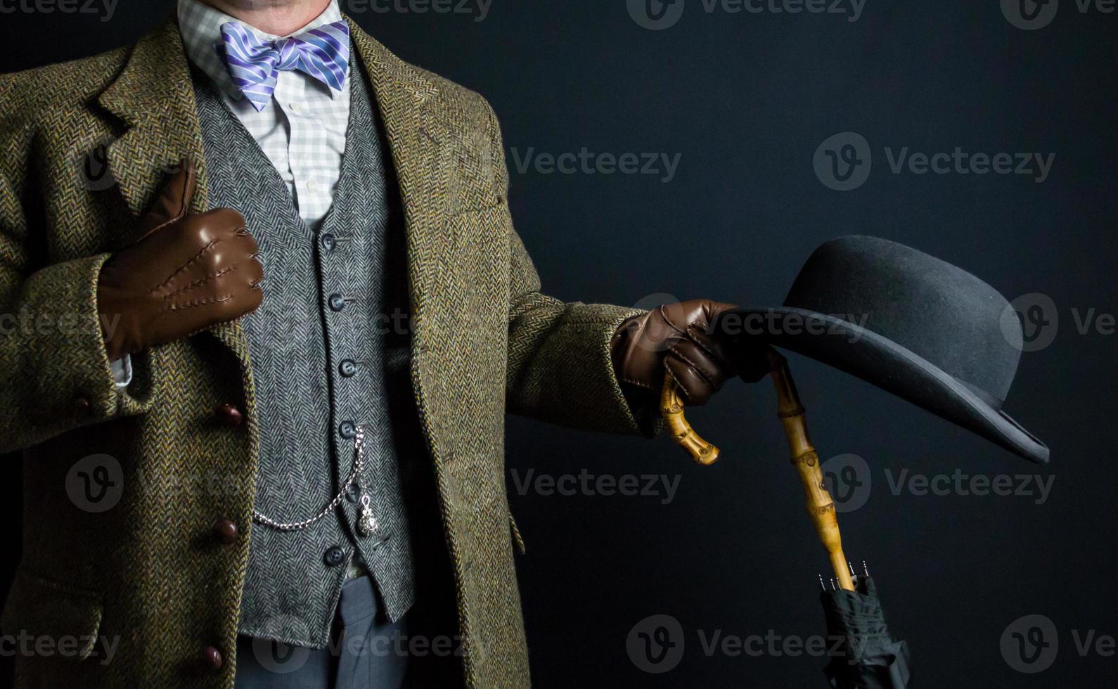 Portrait of Elegant English Gentleman in Tweed Suit Holding Umbrella and Bowler Hat. Vintage Style and Retro Fashion of British Gentleman. photo