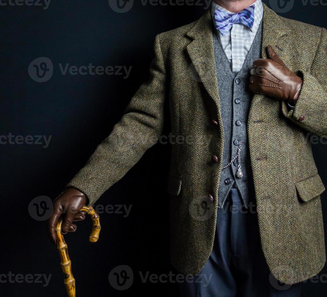retrato de hombre con traje de tweed y guantes de cuero sosteniendo paraguas. estilo vintage de caballero inglés clásico. foto