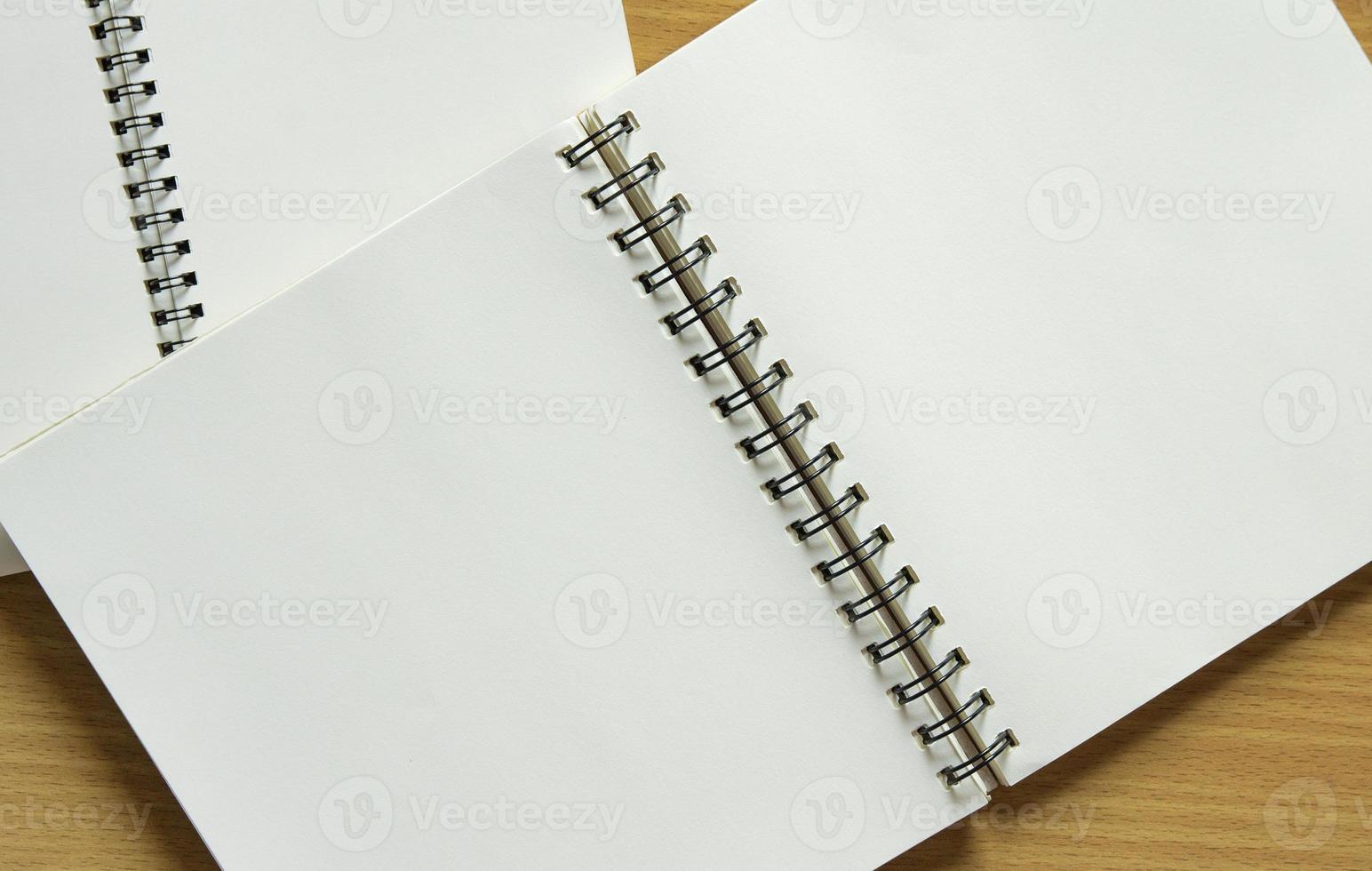 blank spiral notebook on wood background photo