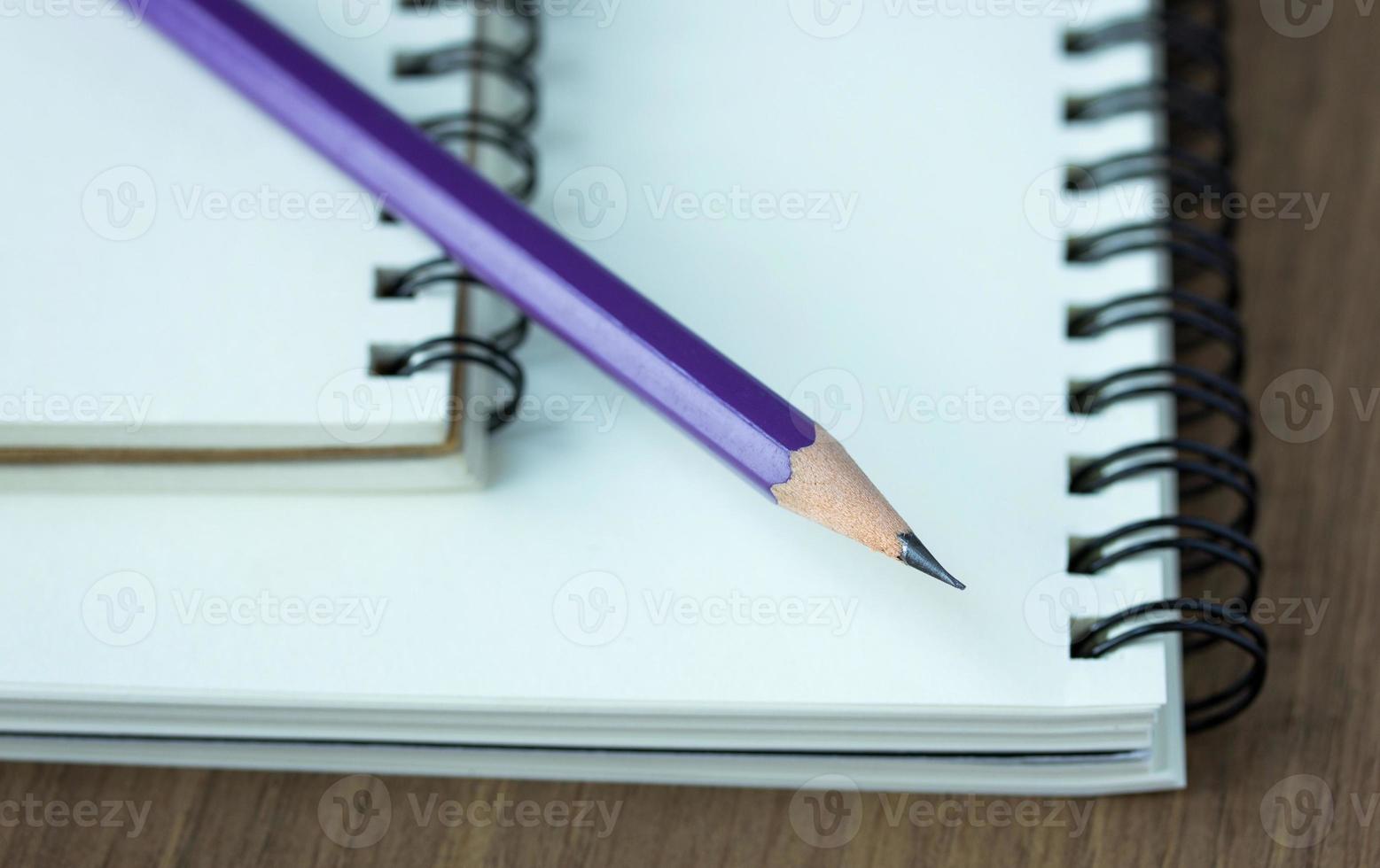 Close up pencil and spiral notebook on wood table, Selective focus point photo
