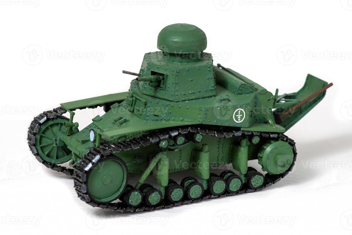 Model of the old Soviet tank of paper on a white background. Look right. The concept of manual labor. photo
