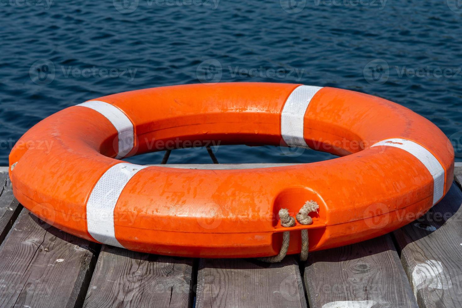 The lifebuoy is lying on a wooden pier. The concept of saving drowning photo