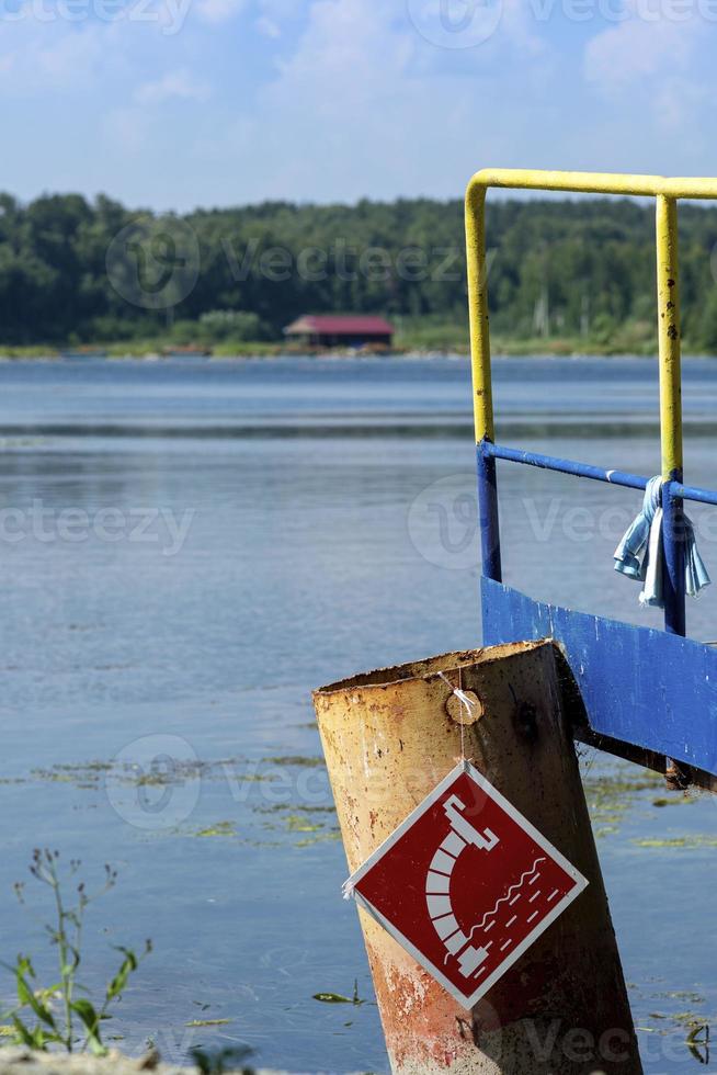 Wooden bridge on the lake shore, water intake sign for fire engines photo