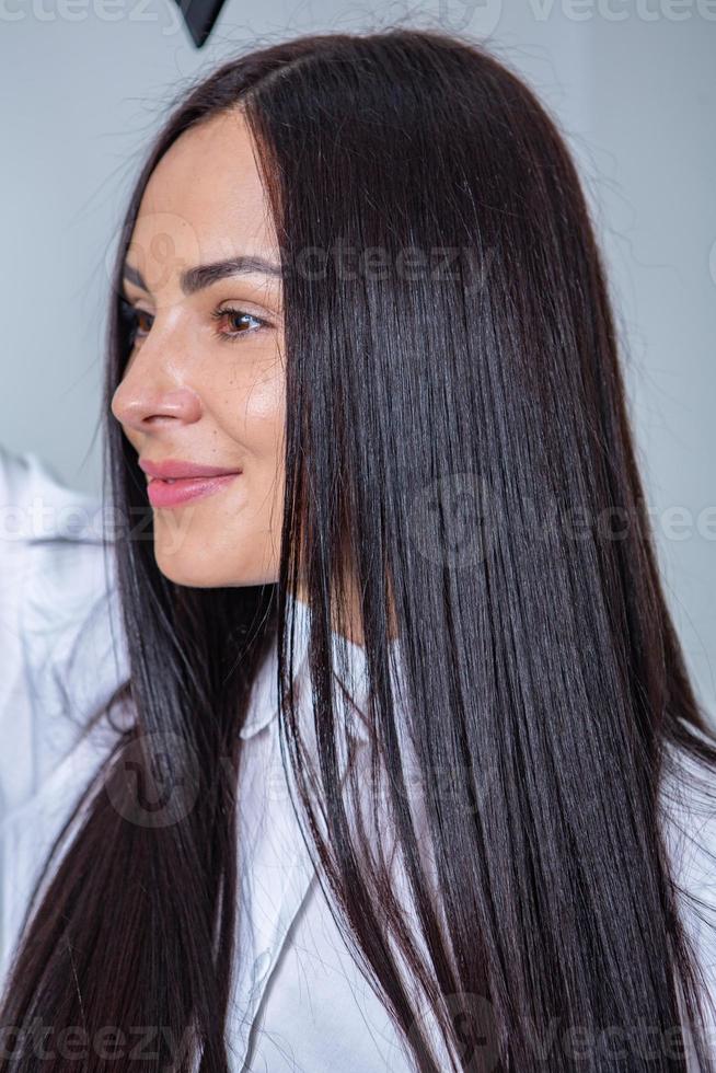 Beautiful young woman with long black hair in a beauty salon. photo