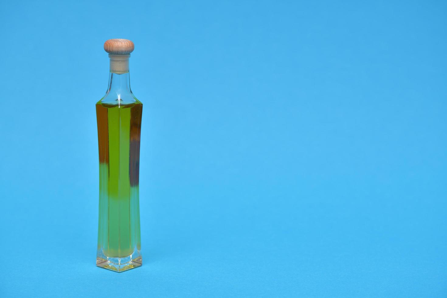 Extra virgin oil in the bottle isolated on blue background photo