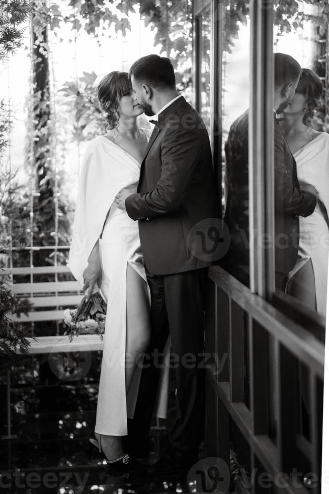 bride in a white dress with a bouquet and the groom in a blue suit photo