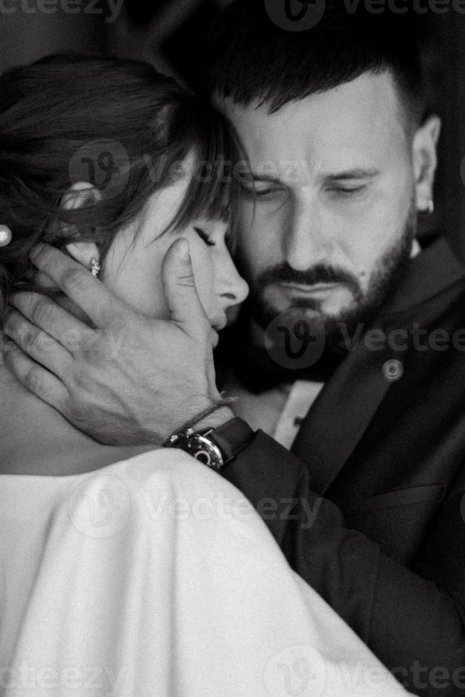 novia con un vestido blanco con un ramo y el novio con un traje azul foto