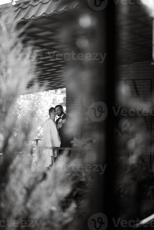 bride in a white dress with a bouquet and the groom in a blue suit photo