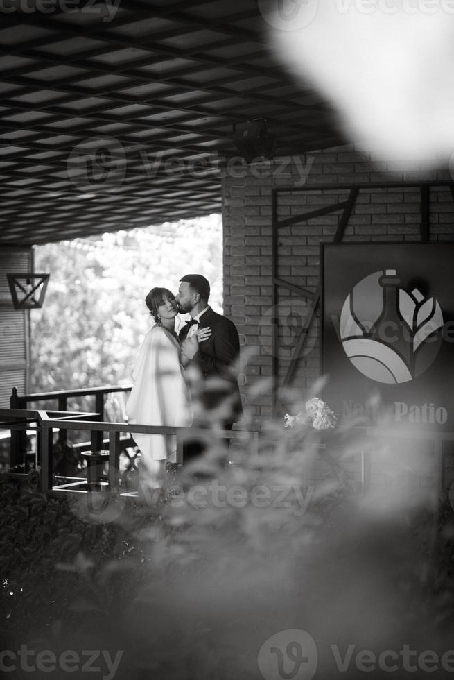 bride in a white dress with a bouquet and the groom in a blue suit photo