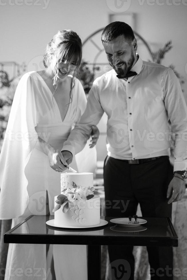 newlyweds happily cut and taste the wedding cake photo