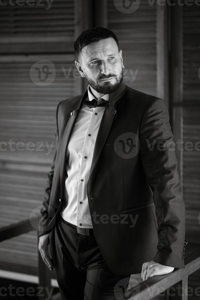 retrato de un novio con barba en un traje azul foto