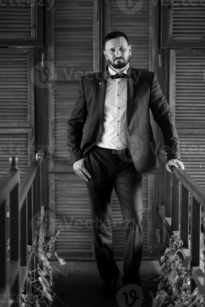 portrait of a groom with a beard in a blue suit photo