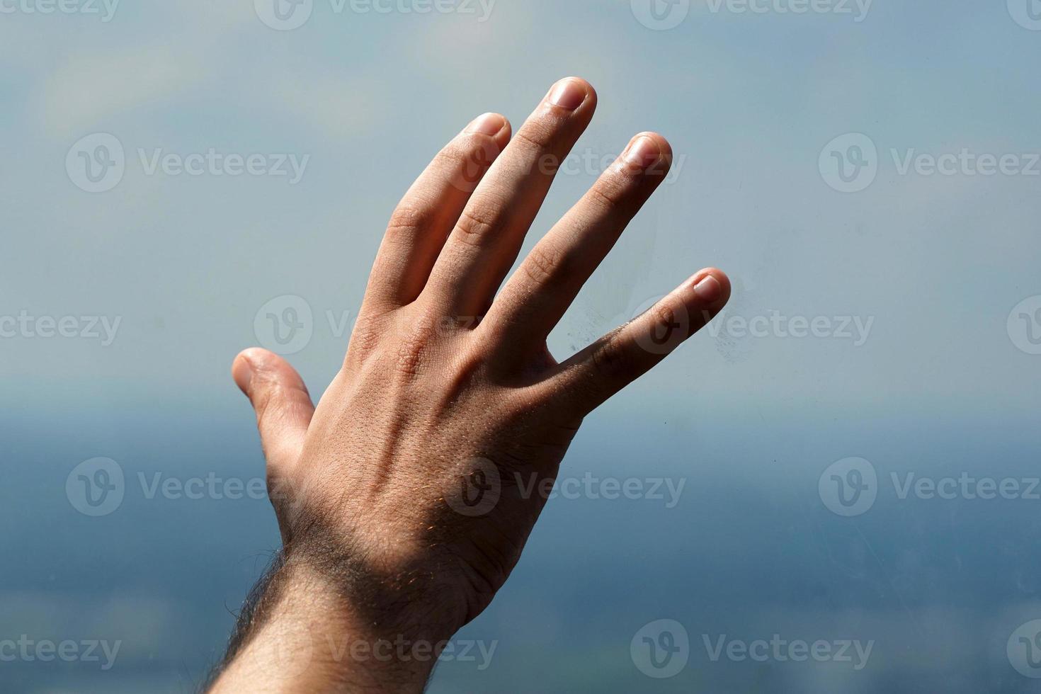 Detalle de la mano del hombre en el cristal de la ventana foto