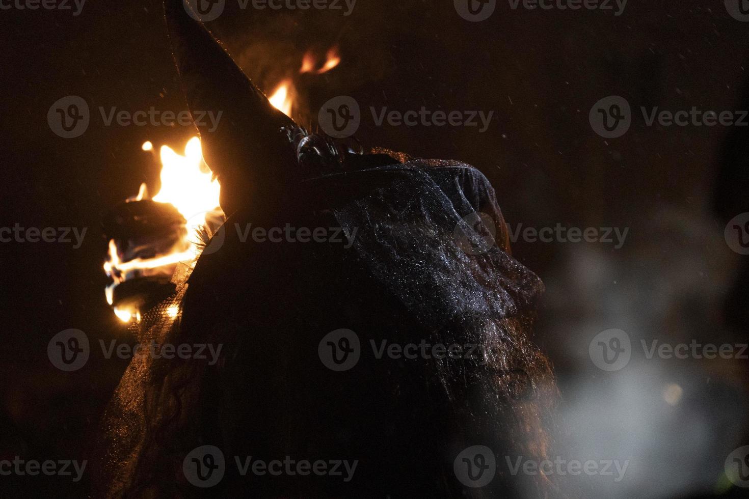 witch in the black holding a torch photo