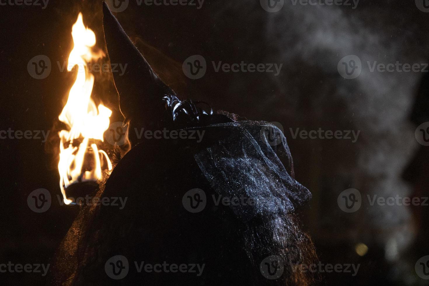 witch in the black holding a torch photo