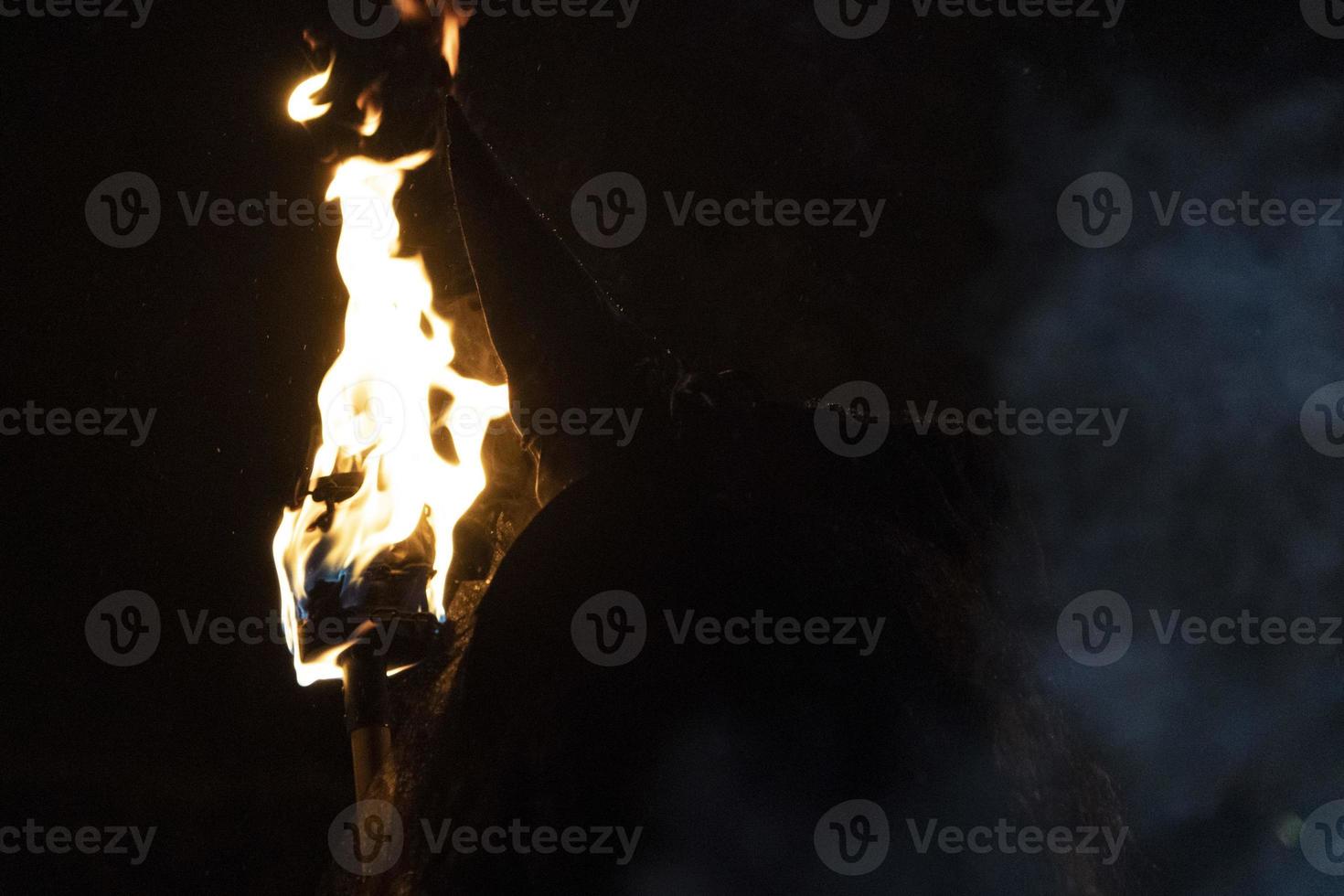 witch in the black holding a torch photo