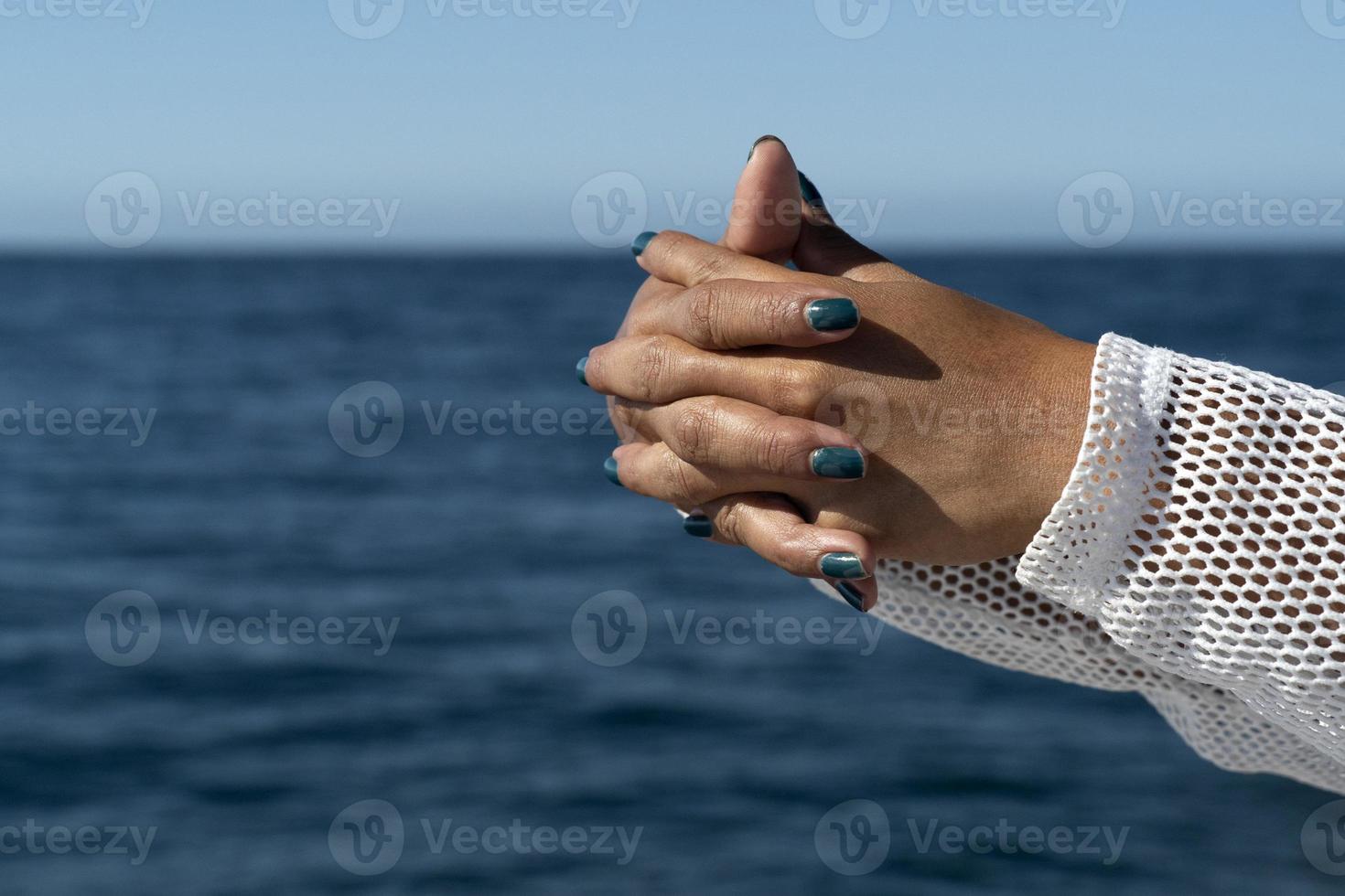 black woman hands on the sea background joined to pray photo