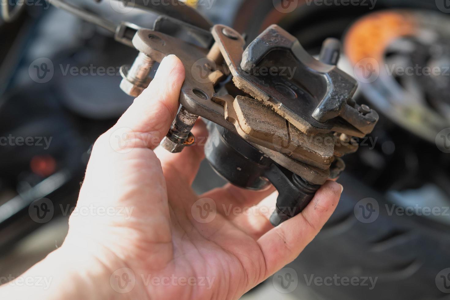 Mechanic check and replace motorcycle Brake system, brake pad , working in garage .repair and maintenance motorcycle concept .selective focus photo