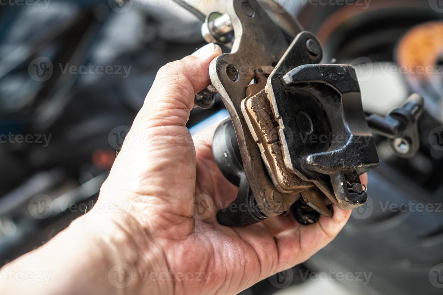 mechanic Replace and adjust motorcycle Brake system, brake pad. maintenance, repair motorcycle concept in garage .selective focus photo