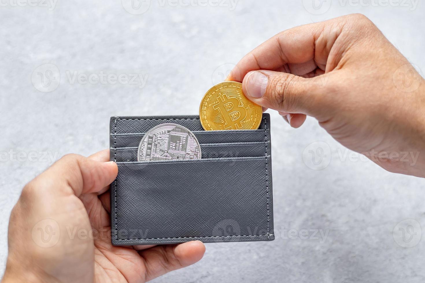 Man holding bitcoin coins. Businessman puts bitcoin coins in a wallet. The concept of buying bitcoins. Bitcoin and wallet. Preservation. Cryptocurrency. virtual money photo