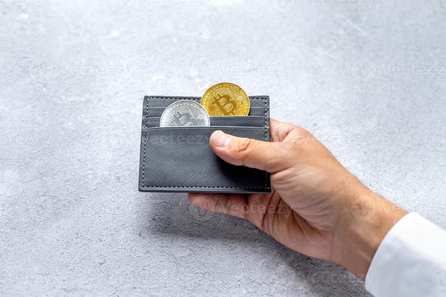 Metal bitcoins in a gray leather wallet. Bitcoin - a modern virtual form of money photo