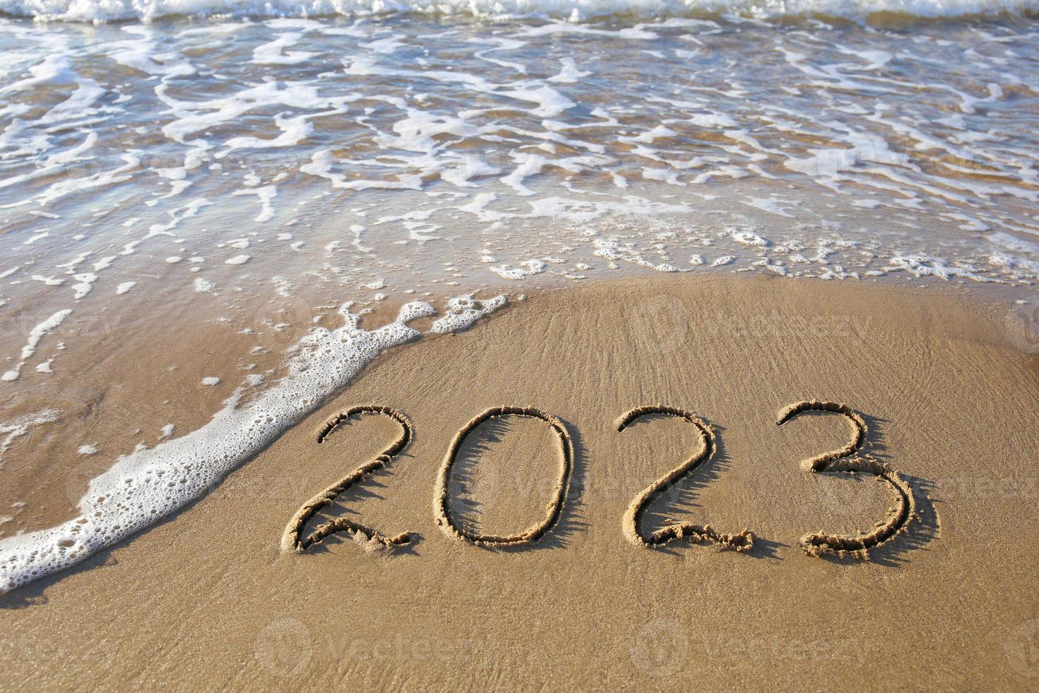 2023 año escrito en el mar de playa de arena. vista superior. endecha plana foto