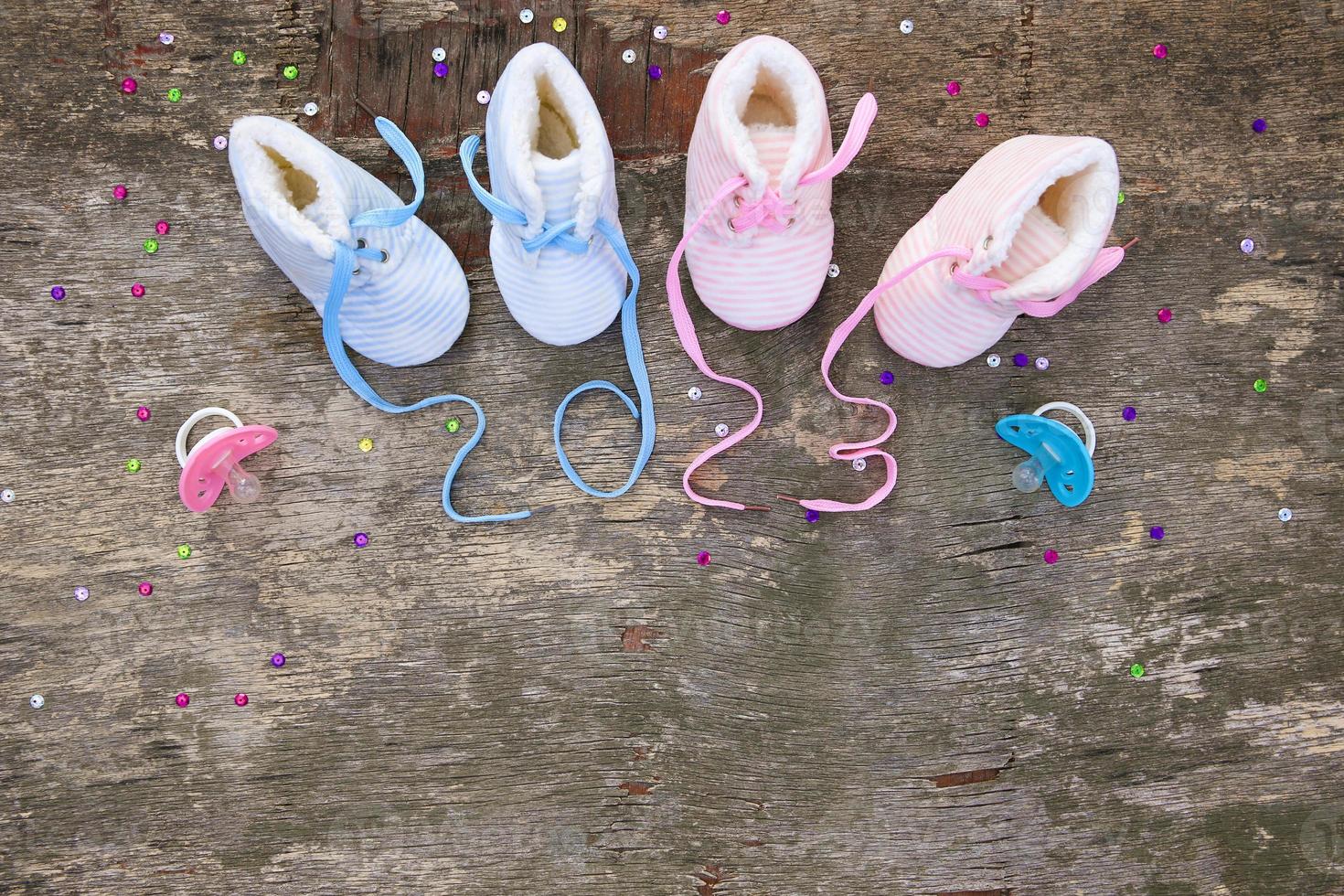 2023 new year written laces of children's shoes and pacifier on old wooden background. Top view. Flat lay. Space for text. photo