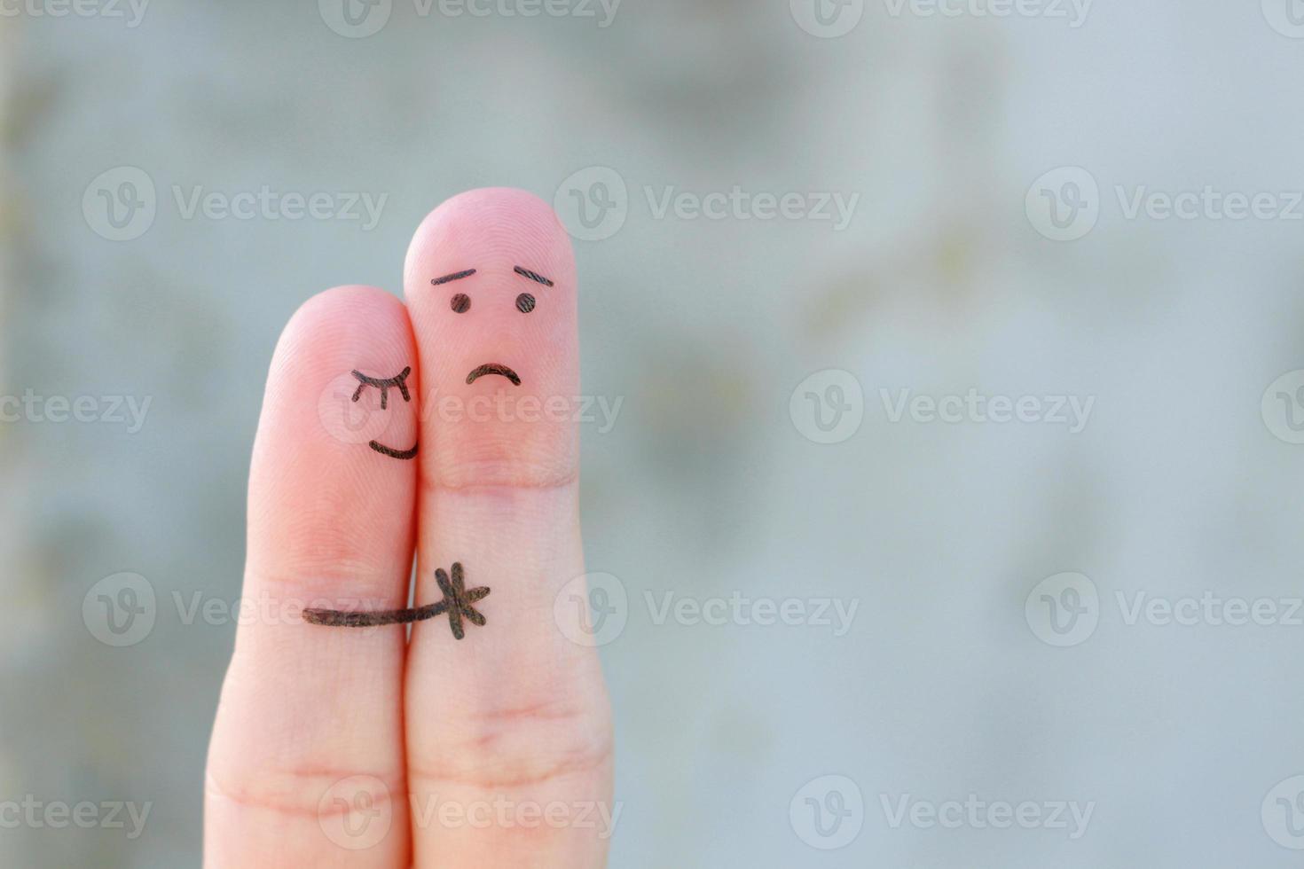 Fingers art of displeased couple. Man is sad, woman reassures her. She kisses and hugs hes. photo